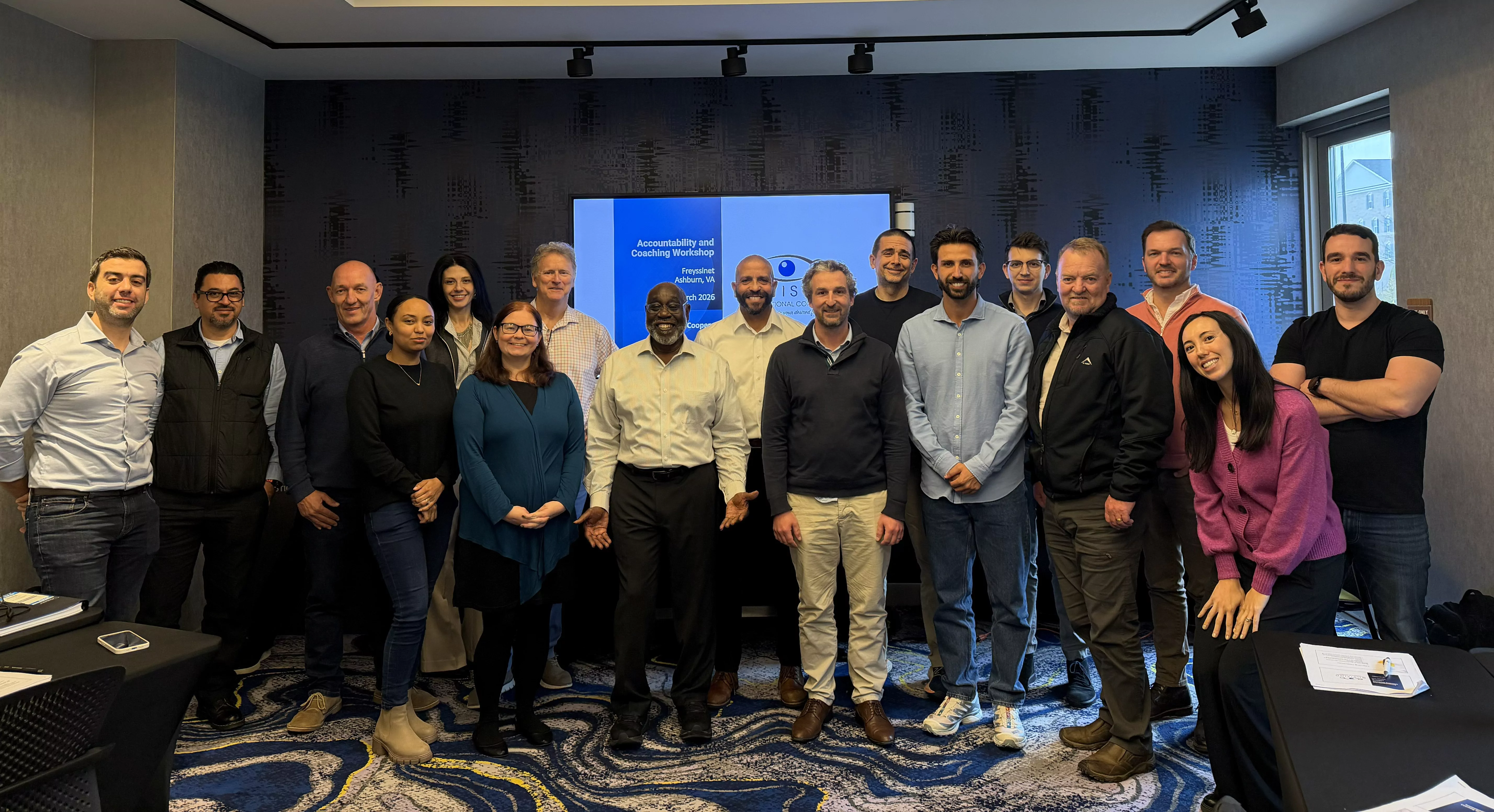 A group of employees standing in front of a projector for a management training session.