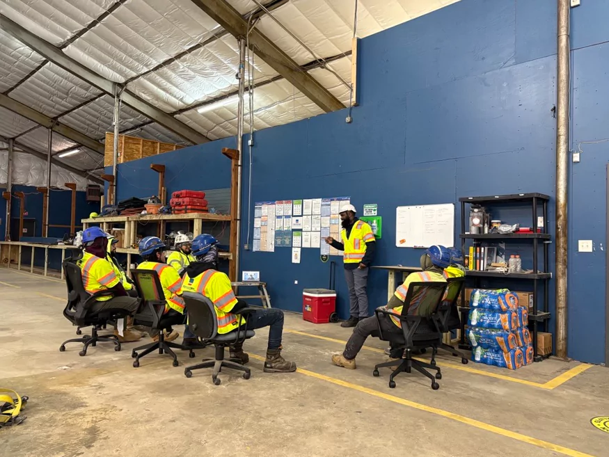 A group of construction workers having a safety meeting prior to working.